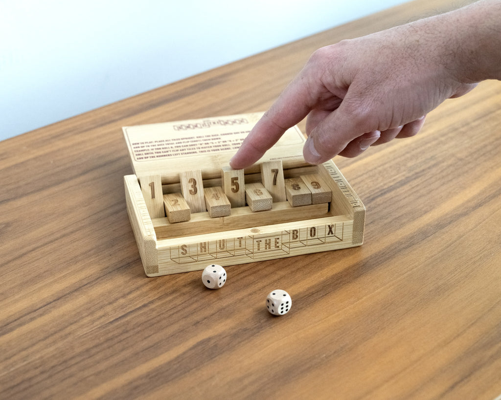 Shut the Box bamboo dice game mid-play with tiles flipped down