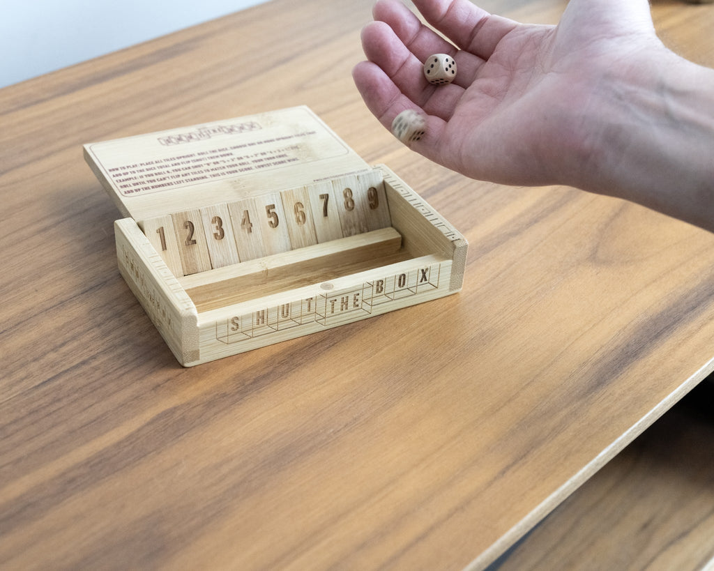 Shut the Box bamboo dice game with dice being rolled